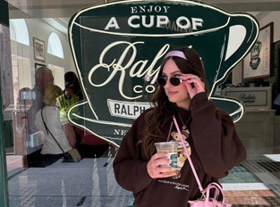 Woman posing in front of Ralph's Coffee