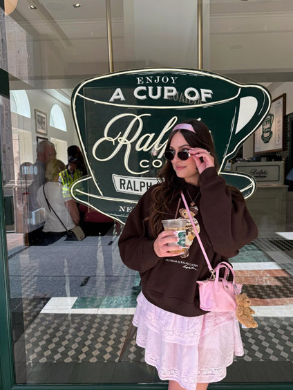 Woman posing in front of Ralph's Coffee